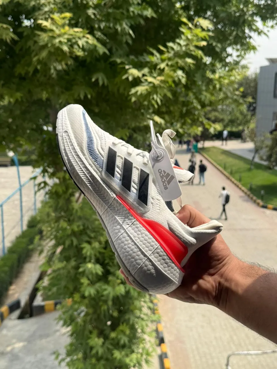 Front view of Adidas Ultraboost Light - Cloud White / Core Black / Solar Red